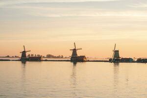 Beliebt Tourist Stelle zaanse schans ist in der Nähe von Amsterdam im das Westen von das Niederlande. historisch, realistisch Windmühlen während Sonnenaufgang. Hollands Wahrzeichen foto