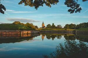 Morgen Sonne leuchtet das Kirche und See um das Stadt, Dorf von naarden im das zentral Teil von das Niederlande. ein historisch Wahrzeichen. Sonnenaufgang glühen foto