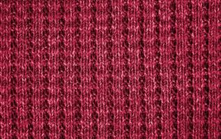 Textur von gestrickt wolle Stoff farbig im das Farbe von das Jahr 2023 viva Magenta 18-1750. Banner. oben Sicht. Nahansicht. selektiv Fokus. foto