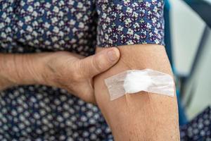 Asiatische Senioren oder ältere Frauenpatienten zeigen Watte aufhören zu bluten, nach Blutentnahmetests für die jährliche körperliche Gesundheitsprüfung, um Cholesterin, Blutdruck und Zuckerspiegel zu überprüfen foto