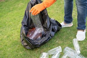 asiatische frau freiwillig tragen wasserplastikflaschen in müllsackmüll im park, recyceln abfall umweltökologiekonzept foto