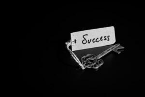 Schlüssel zu Erfolg Konzept - - alt Schlüssel mit Erfolg Etikett isoliert auf schwarz Hintergrund foto