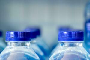 Mineral Wasser Flaschen im ein Reihe mit Blau Kappen foto