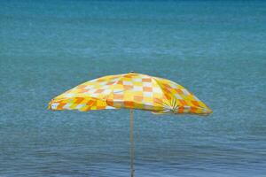 Strand Regenschirm von das Sonne auf das Strand. schwarz Meer foto