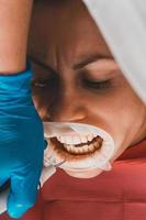 Zahnsteinentfernung, Einsatz von Ultraschall, Patient und Zahnarzt. foto