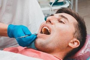 Besuch beim Zahnarzt, der Zahnarzt beurteilt die Mundhöhle