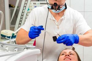 der Zahnarzt entfernt das überschüssige Material vom Zahn