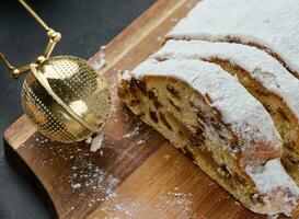 Weihnachten Gebäck Stollen bestreut mit pulverisiert Zucker auf das Tisch, festlich Dessert foto