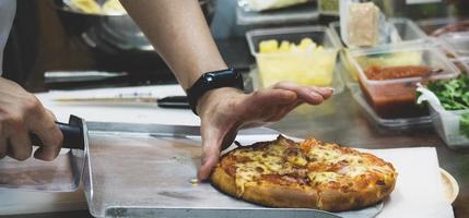 Koch bereitet Pizza zu, der Prozess der Pizzaherstellung foto