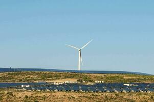 ein Wind Turbine und Solar- Paneele auf ein Hang foto