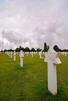 das Weiß Kreuze im das Gras beim das amerikanisch Friedhof foto