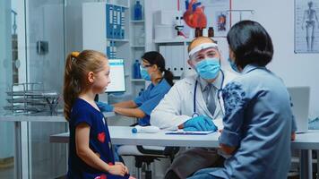 Mutter erklären zu Arzt Mädchen Symptome während Coronavirus im medizinisch Büro. Kinderarzt Spezialist im Medizin mit Maske Bereitstellung Gesundheit Pflege Dienstleistungen Beratung, Behandlung im Krankenhaus Kabinett foto