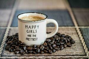 glücklich Mädchen sind das am hübschesten geschrieben im ein Weiß Keramik Tasse mit Kaffee, auf ein einstellen Weiß Tabelle foto