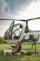 heiter Tween Mädchen spielen mit Hündchen in der Nähe von Hubschrauber foto