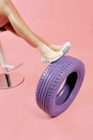 weiblich Beine im Beige Socke Turnschuhe gelehnt auf Auto Reifen foto