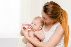 Fütterung Baby. Baby Essen Milch von das Flasche. foto