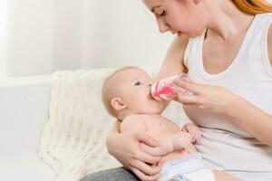 Fütterung Baby. Baby Essen Milch von das Flasche. foto