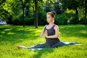 jung Frau tun Yoga Übungen im das Sommer- Stadt Park. foto