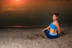 Yoga beim Sonnenuntergang auf das Strand. foto