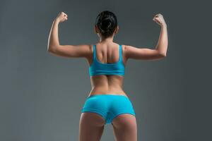 jung sportlich Mädchen zeigt an Muskeln foto