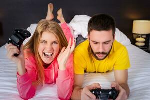 jung Paar haben Spaß spielen Videospiele im Bett foto