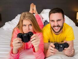glücklich jung Paar haben Spaß spielen Videospiele im Bett foto