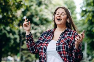 modernes Mädchen hat Spaß beim Singen vor dem Hintergrund der Natur foto