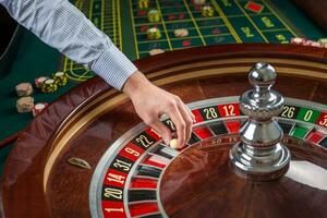 Roulette Rad und Croupier Hand mit Weiß Ball im Kasino foto