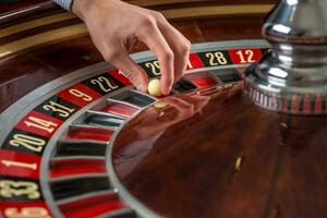 Roulette Rad und Croupier Hand mit Weiß Ball im Kasino foto