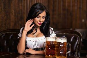 Oktoberfest Frau tragen ein traditionell bayerisch Kleid dirndl posieren mit ein Bier Tassen beim Bar foto