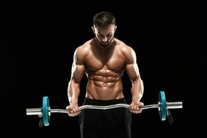 muskulös Mann Heben Gewichte Über dunkel Hintergrund foto