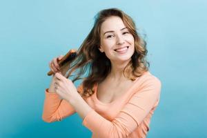 Frau, die ihr langes Haar kämmt. Haarpflege und Erstellen von Frisuren. foto