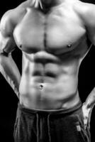 Nahansicht von ein Leistung Fitness Mann auf schwarz Hintergrund foto