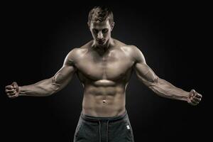 atemberaubend muskulös Mann zeigen perfekt Abs, Schultern, Bizeps, Trizeps, Truhe foto