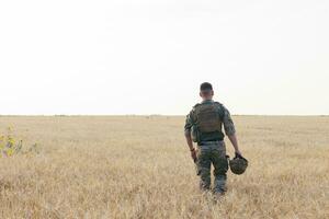 Soldat Mann Stehen gegen ein Feld foto