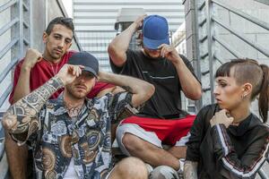 Gruppe von jung Rapper posieren Sitzung auf das Metall Treppe foto