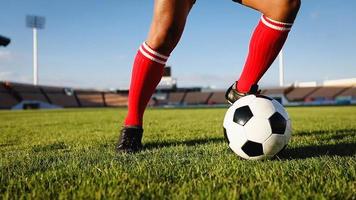 Fußball- oder Fußballspieler, der mit Ball auf dem Feld steht, um den Fußball im Fußballstadion zu treten foto