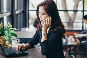 Geschäftsmänner und -frauen verwenden Mobiltelefone und Touch-Smartphones für die Kommunikation und die Überprüfung von Geschäftsleuten im Bürohintergrund foto