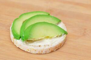 Reis Kuchen Sandwich mit frisch Avocado und Sahne Käse auf Bambus Schneiden Tafel. einfach Frühstück. Diät Lebensmittel. schnell und gesund Sandwiches. Knäckebrot mit lecker Füllung. gesund Diät Snack foto