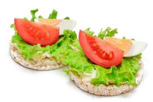 Reis Kuchen Sandwiches mit Tomate, Grüner Salat und Ei isoliert auf Weiß. einfach Frühstück. Diät Lebensmittel. schnell und gesund Sandwiches. Knäckebrot mit lecker Füllung. gesund Diät Snack Isolierung foto