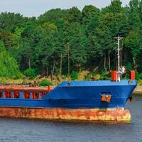 Blau Ladung Schiff mit lange erreichen Bagger ziehen um zu das Hafen foto