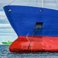 Blau Ladung Schiff festgemacht im immer noch baltisch Meer Wasser foto