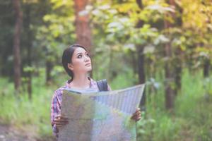 junge Wandererinnen, die sich die Karte ansehen und sich beim Urlaubskonzept im Wald entspannen?