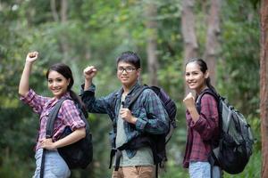 Asiatische Gruppe junger Leute, die mit Freunden wandern, Rucksäcke, die zusammen spazieren gehen und eine Karte suchen und eine Fotokamera an der Straße machen und glücklich aussehen, entspannen Sie sich bei Urlaubskonzeptreisen foto