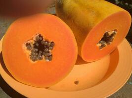 das Papaya Früchte auf ein hölzern Tabelle und ein rustikal Stoff beim das Hintergrund foto