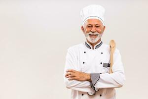 Porträt von Senior Koch mit Arbeit Werkzeug auf grau Hintergrund. foto