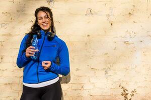 schön sportlich Frau Trinken Wasser draussen. foto