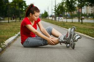 jung Frau auf Walze Rollschuhe hat Sport Verletzung foto