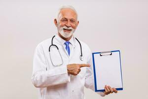 Porträt von Senior Arzt zeigen beim Zwischenablage auf grau Hintergrund. foto