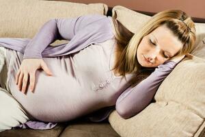 schwanger Frau ist Schlafen auf Sofa foto